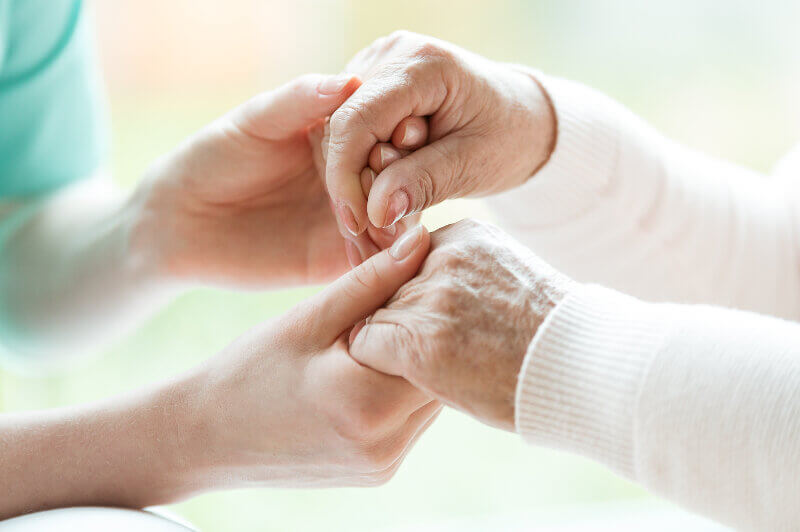 Elderly woman and Carer holding hands